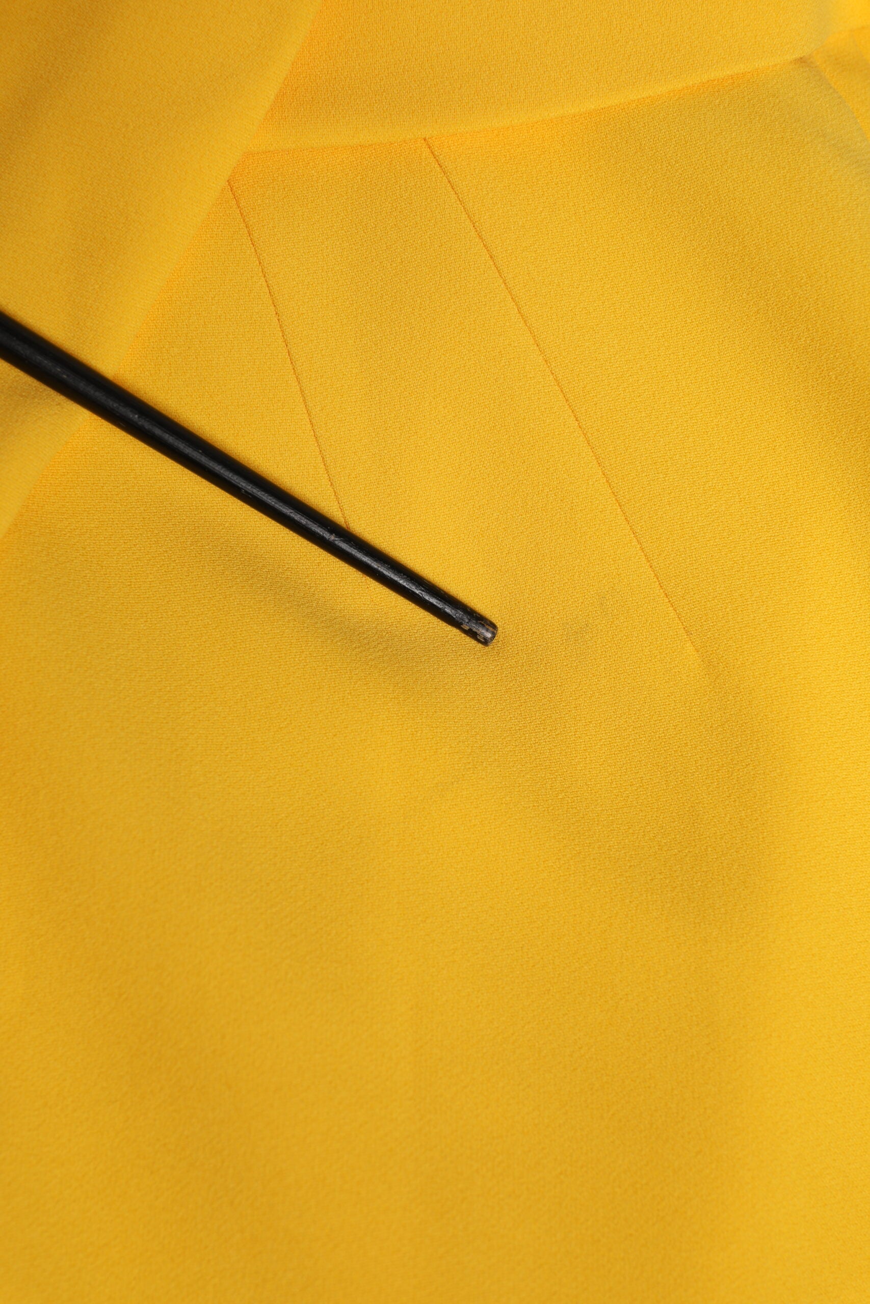 Yellow fabric with black pin in it