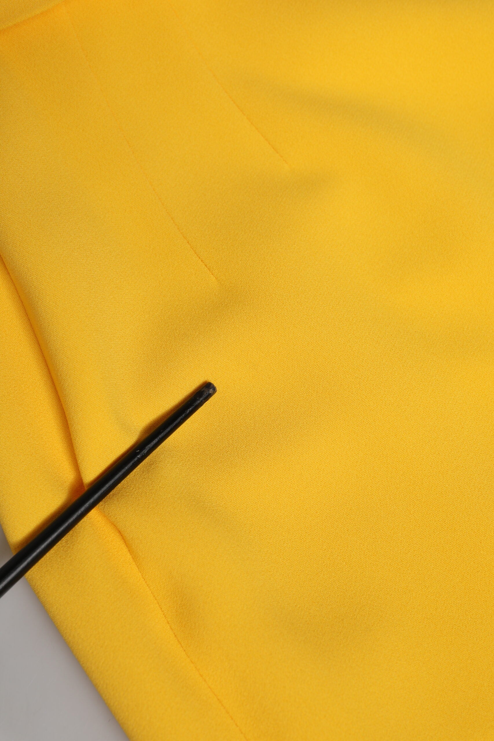 Yellow fabric with black pin