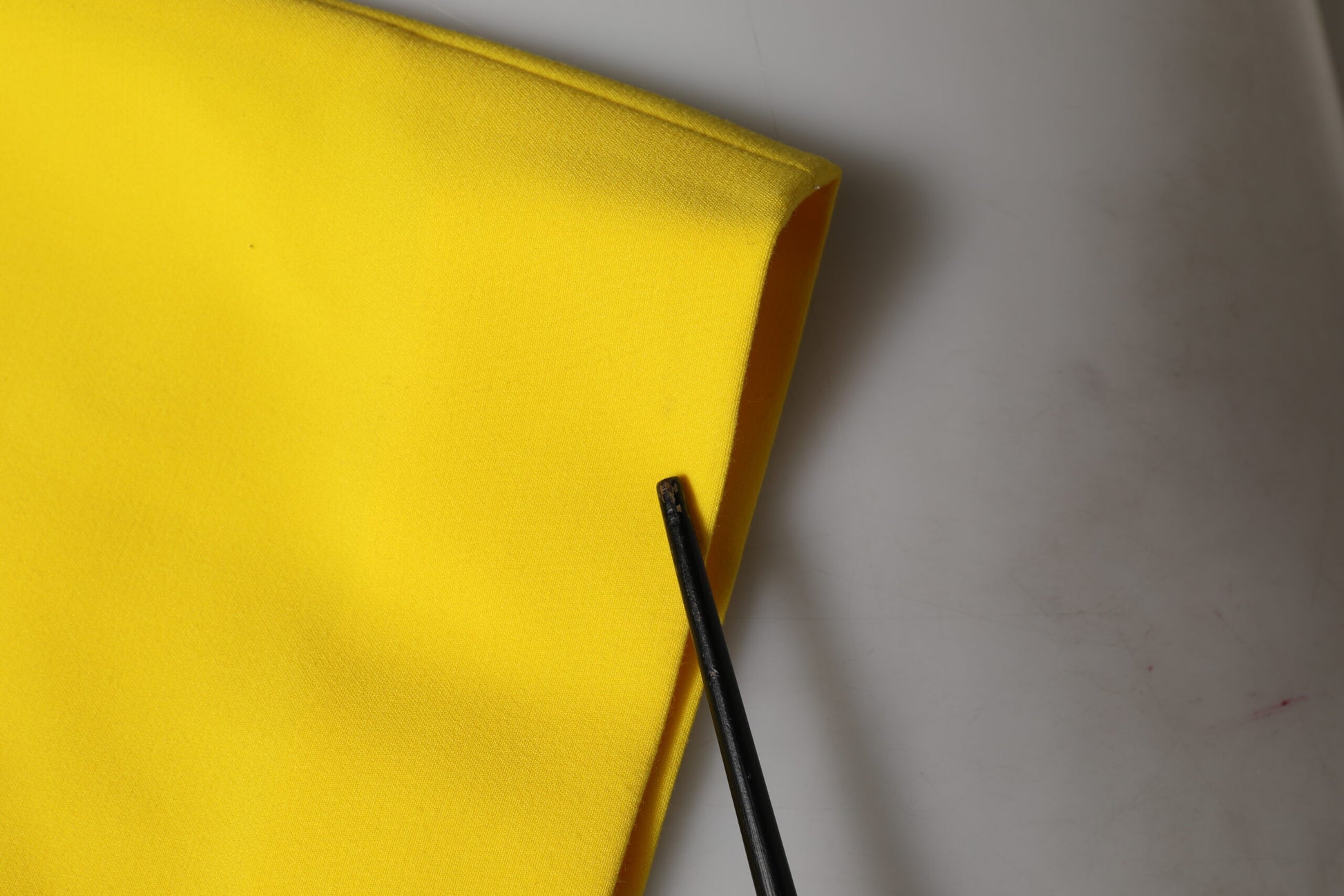 A yellow sleeveless sheath midi dress with a black zipper
