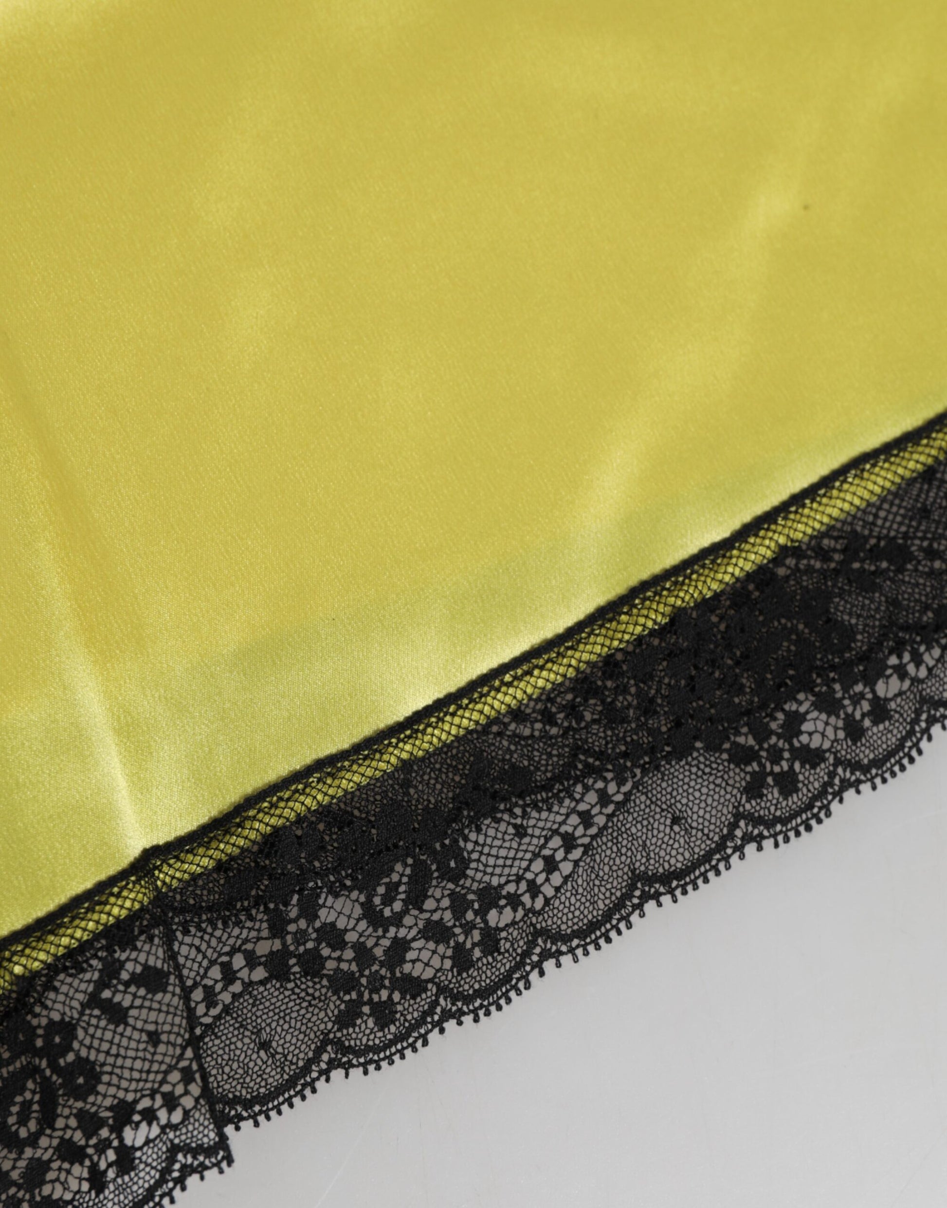 A pair of yellow satin silk mid waist underwear shorts with black lace trim