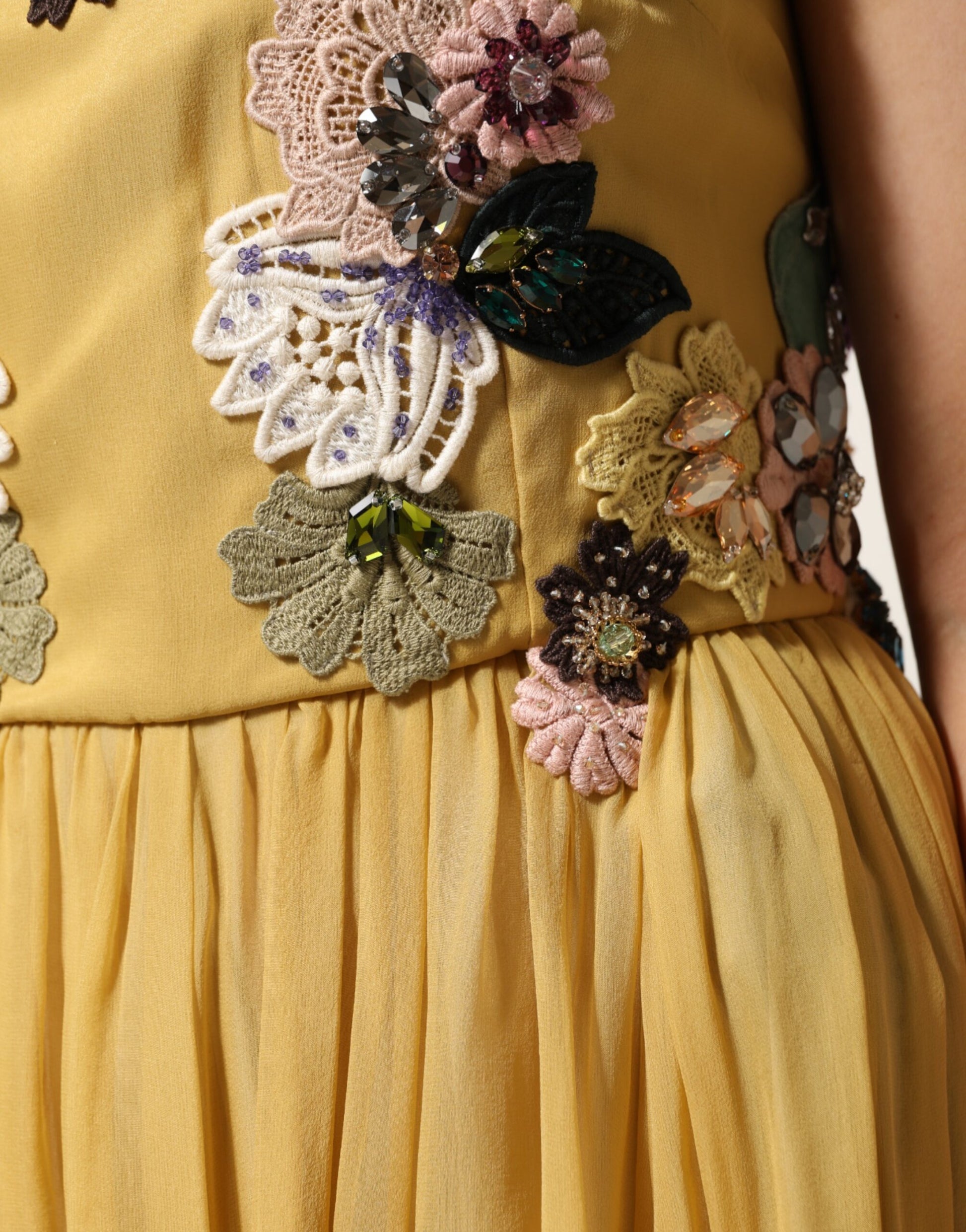 A yellow silk dress with floral embroidery and ruffles on the sleeves