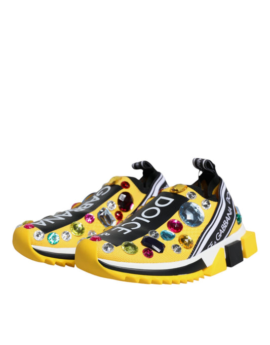 A pair of yellow sneakers with crystal embellishments and a black logo
