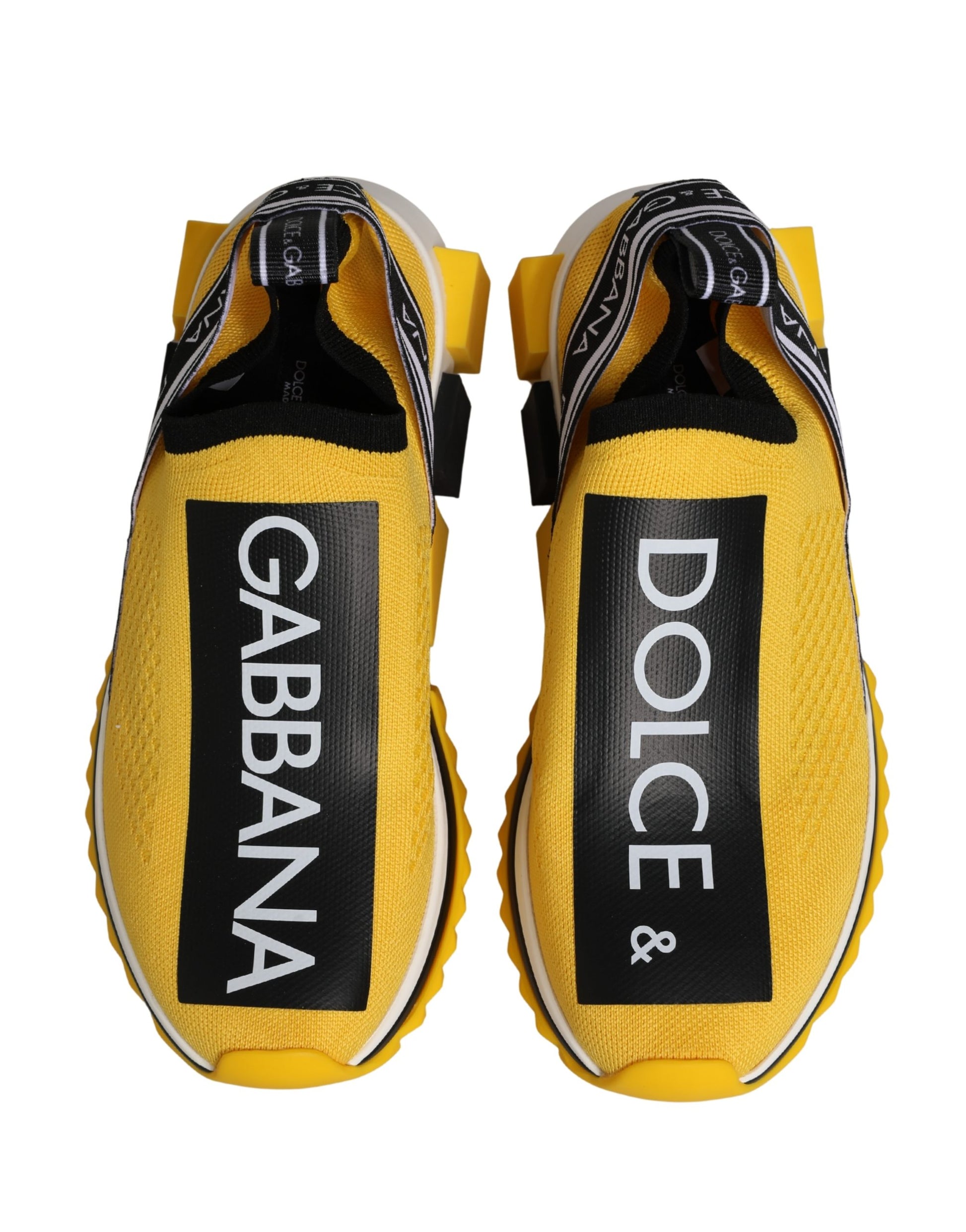 Pair of yellow slip-on shoes with black and white text branding