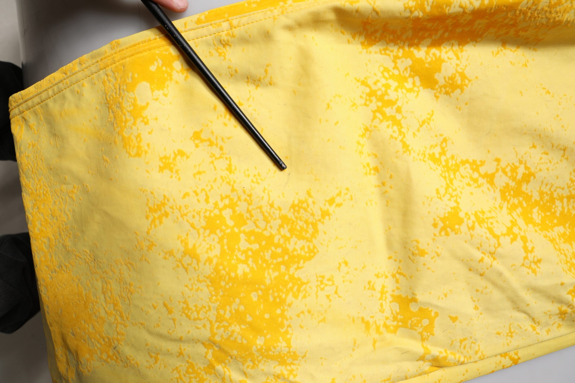 Yellow fabric with yellow paint splatters