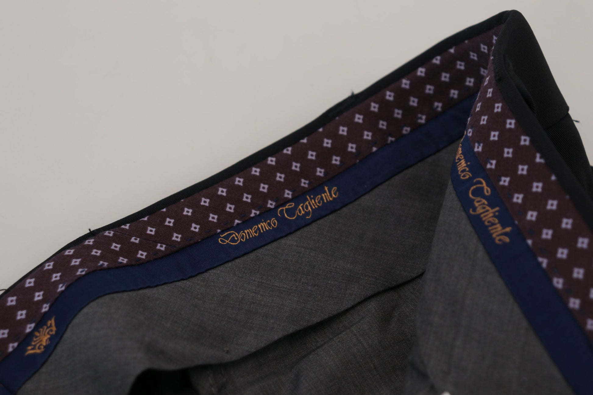 A pair of black polyester tapered dress pants with a patterned waistband and belt loops