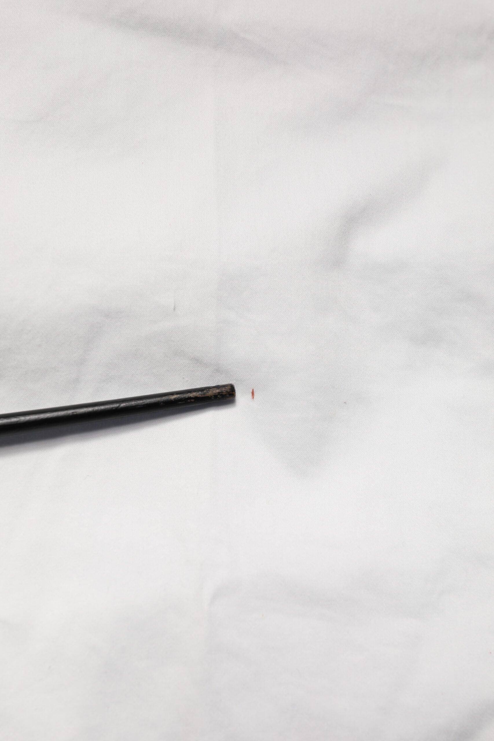 Black tapered dress pants with a small red stain on the left leg