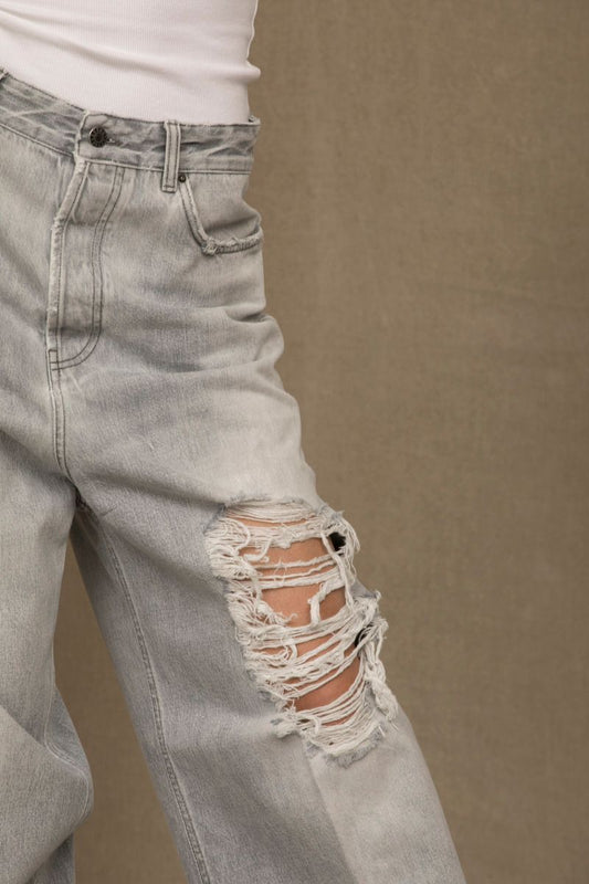 Pair of distressed jeans with holes in knees
