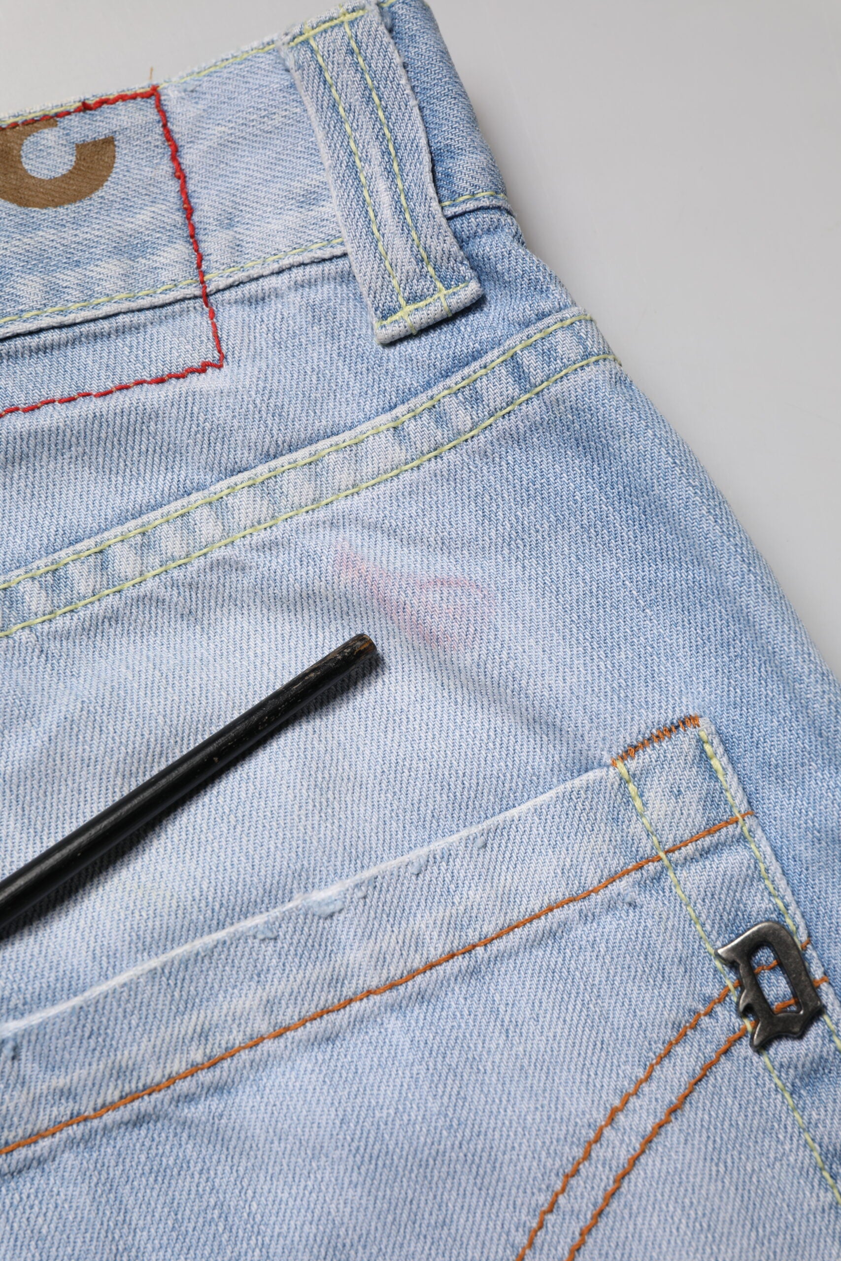 Blue denim jeans with red stitching on front pocket
