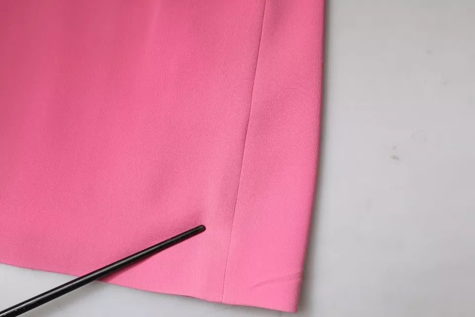 A pink viscose short sleeve backless sheath mini dress with a black pen resting on it