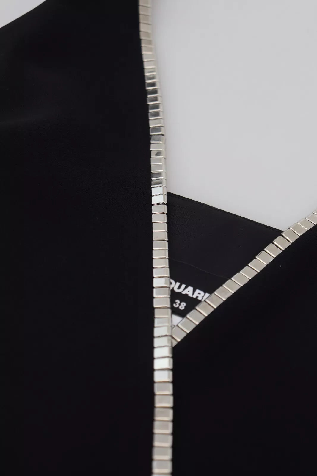 A black dress with silver embellishments on the neckline and sleeves