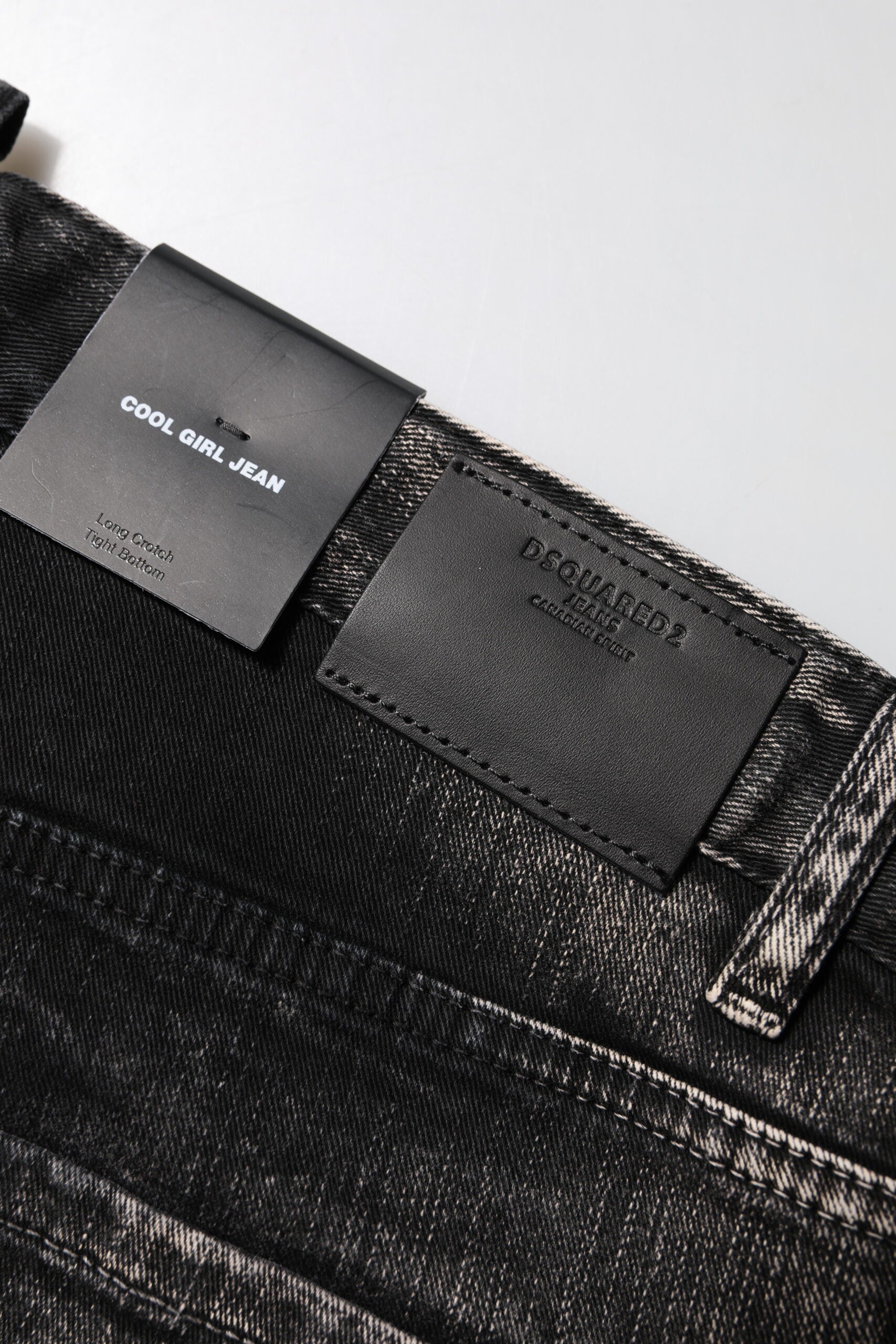 Black denim jeans on a white surface