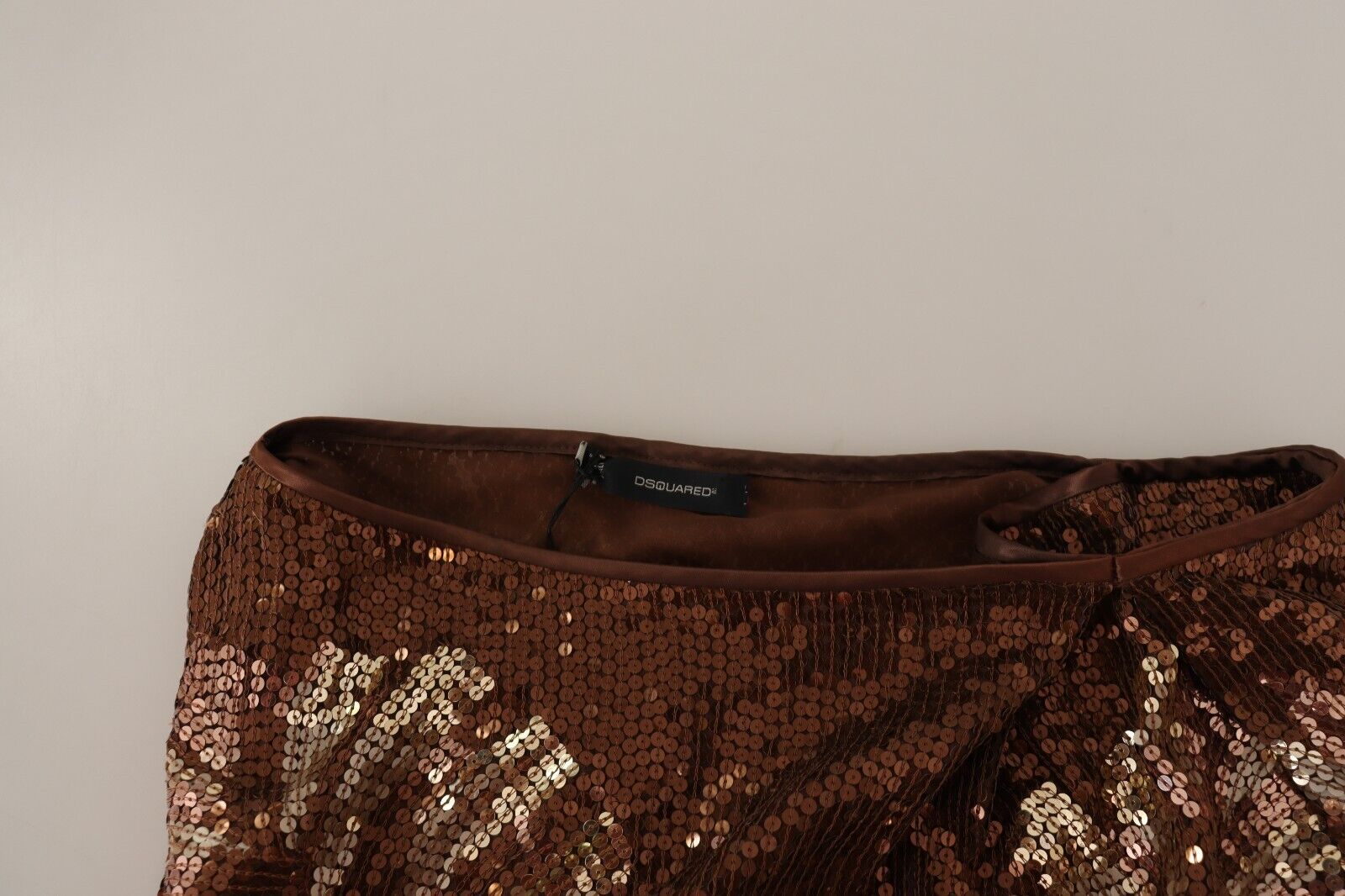 A brown sequined dress with a leaf pattern on one shoulder, long sleeves and shift style