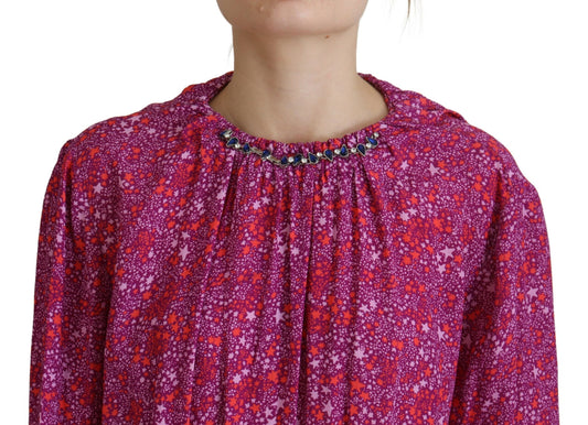 A long sleeve dress with a fuchsia floral pattern and embellishments