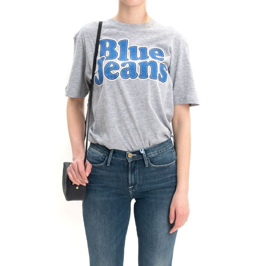 Woman wearing gray t-shirt with blue jeans