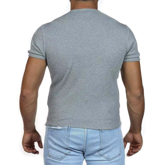 Man wearing gray sweater and blue jeans
