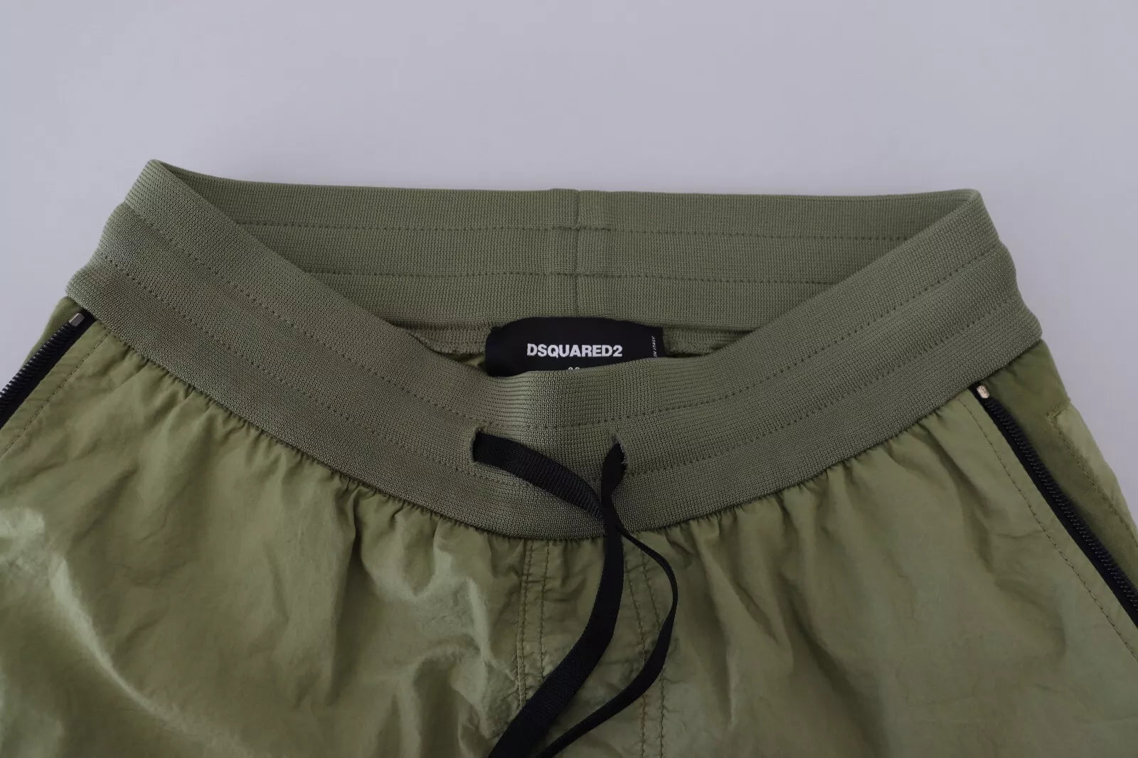 A pair of green cotton shorts with drawstrings, mid-waist, tapered at the bottom