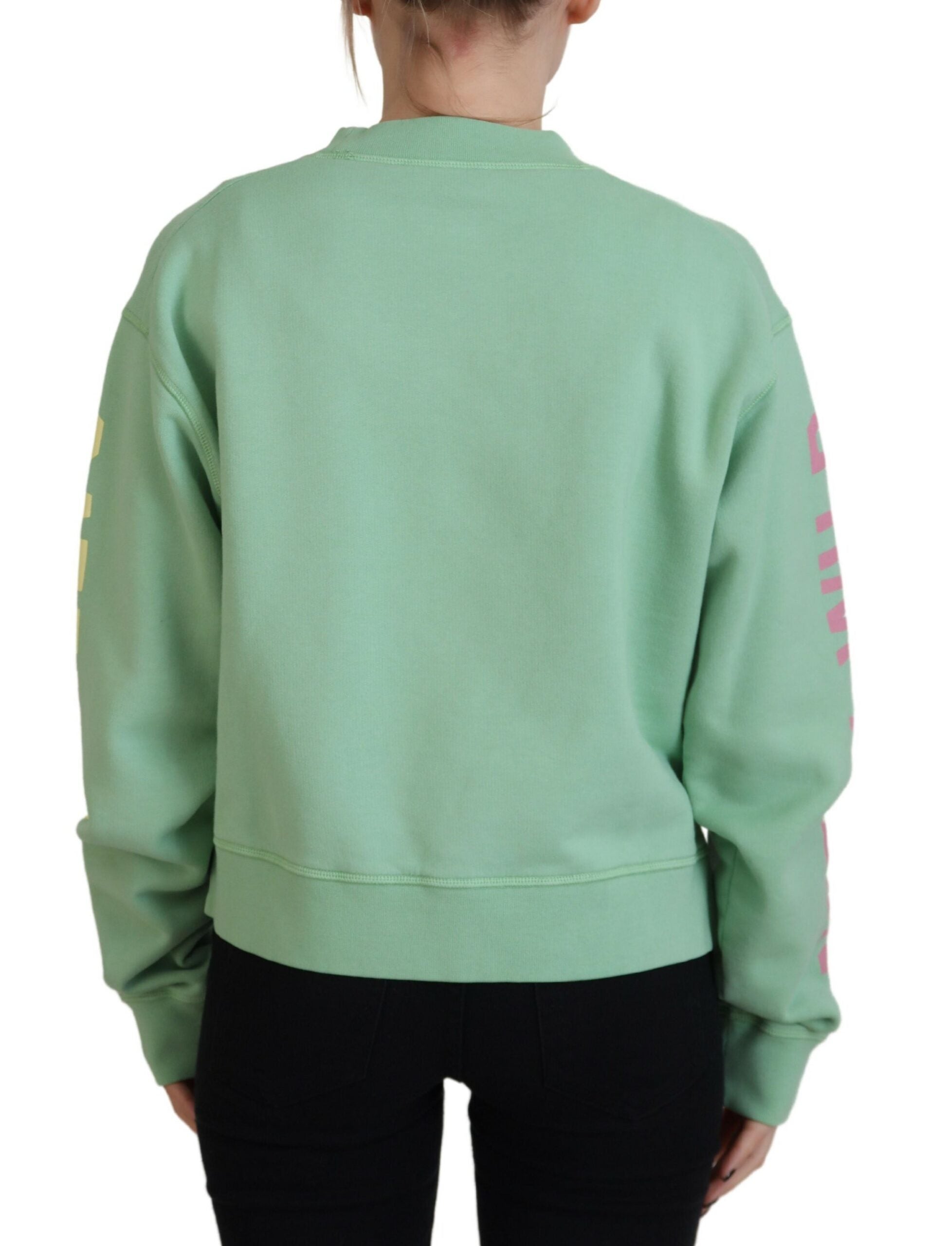Woman wearing green sweatshirt with pink letters