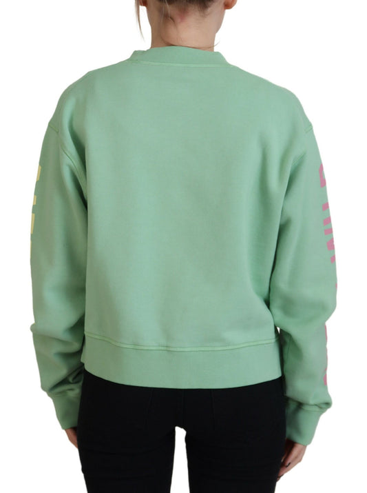 Woman wearing green sweatshirt with pink letters