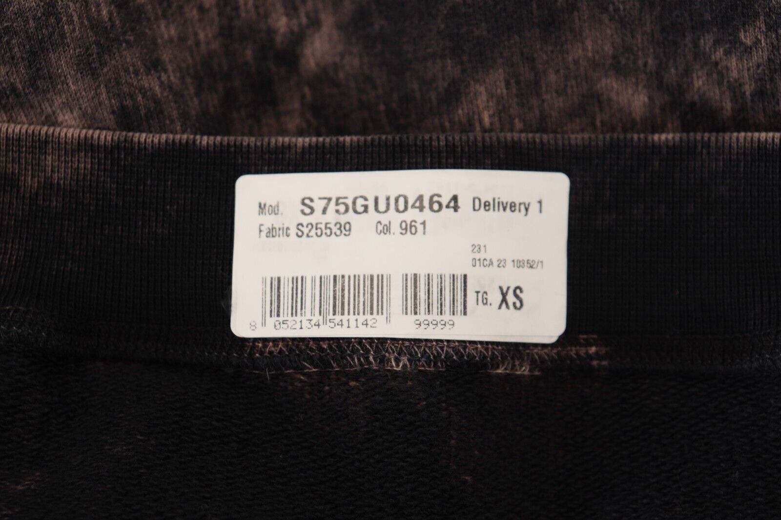 Black label on fabric with white lettering and numbers