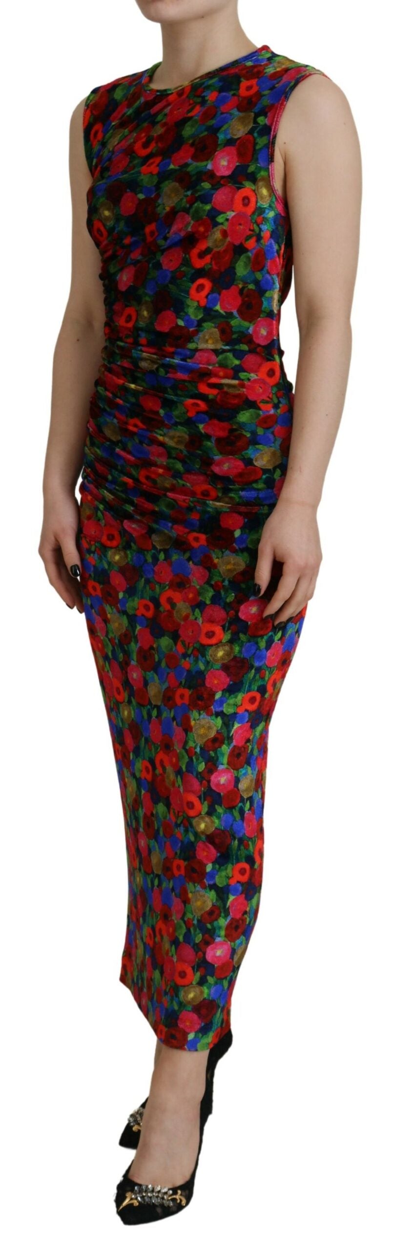 A woman wearing a colorful floral dress with ruched detailing and a body-hugging fit