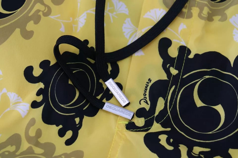 Black necklace with a silver pendant on a yellow patterned fabric