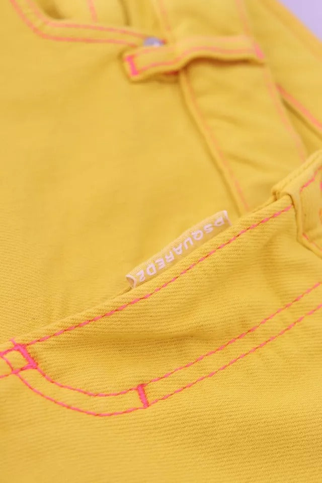 Yellow jeans with pink stitching on front pocket