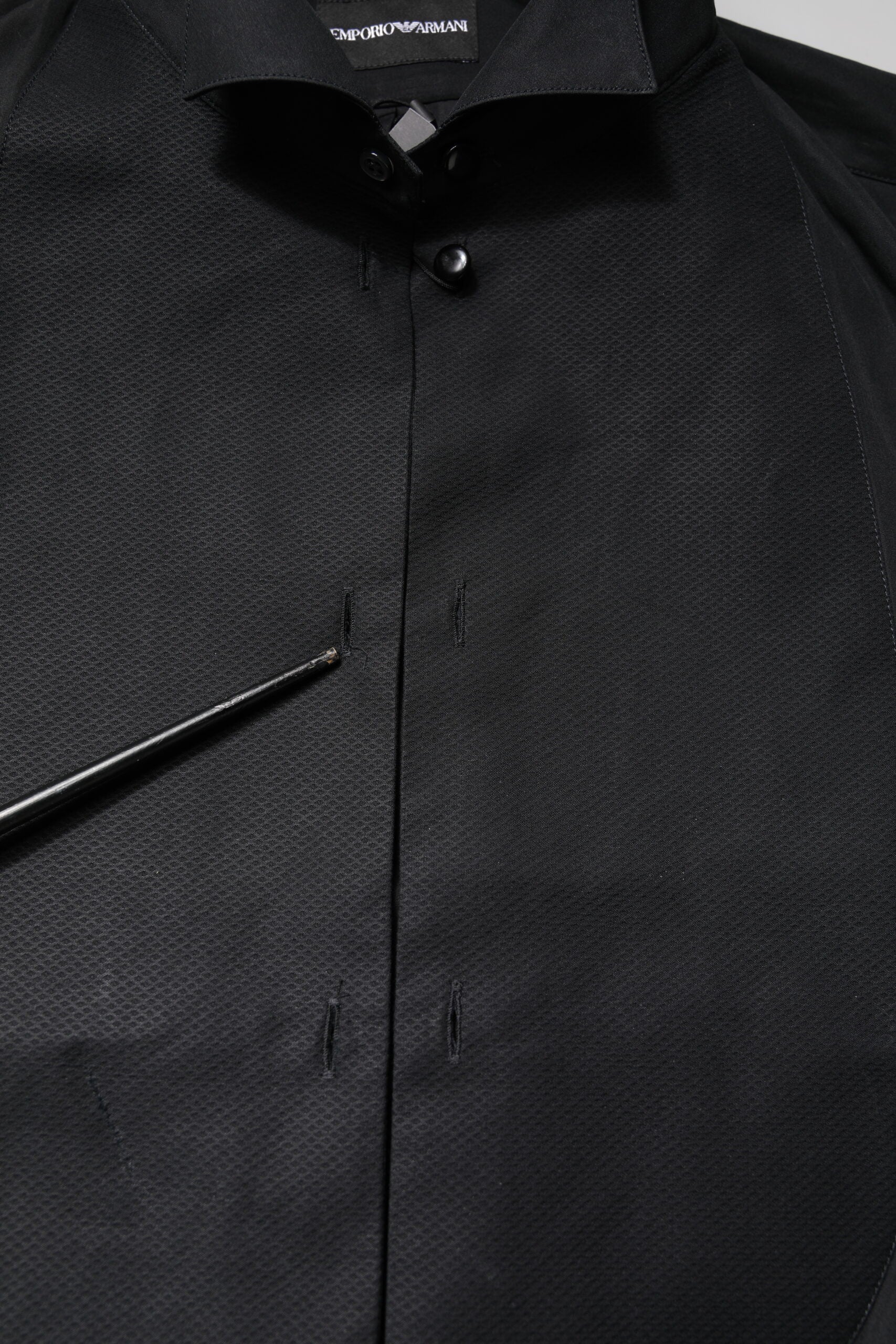 A black cotton dress shirt with long sleeves, featuring a button-up front and a collar