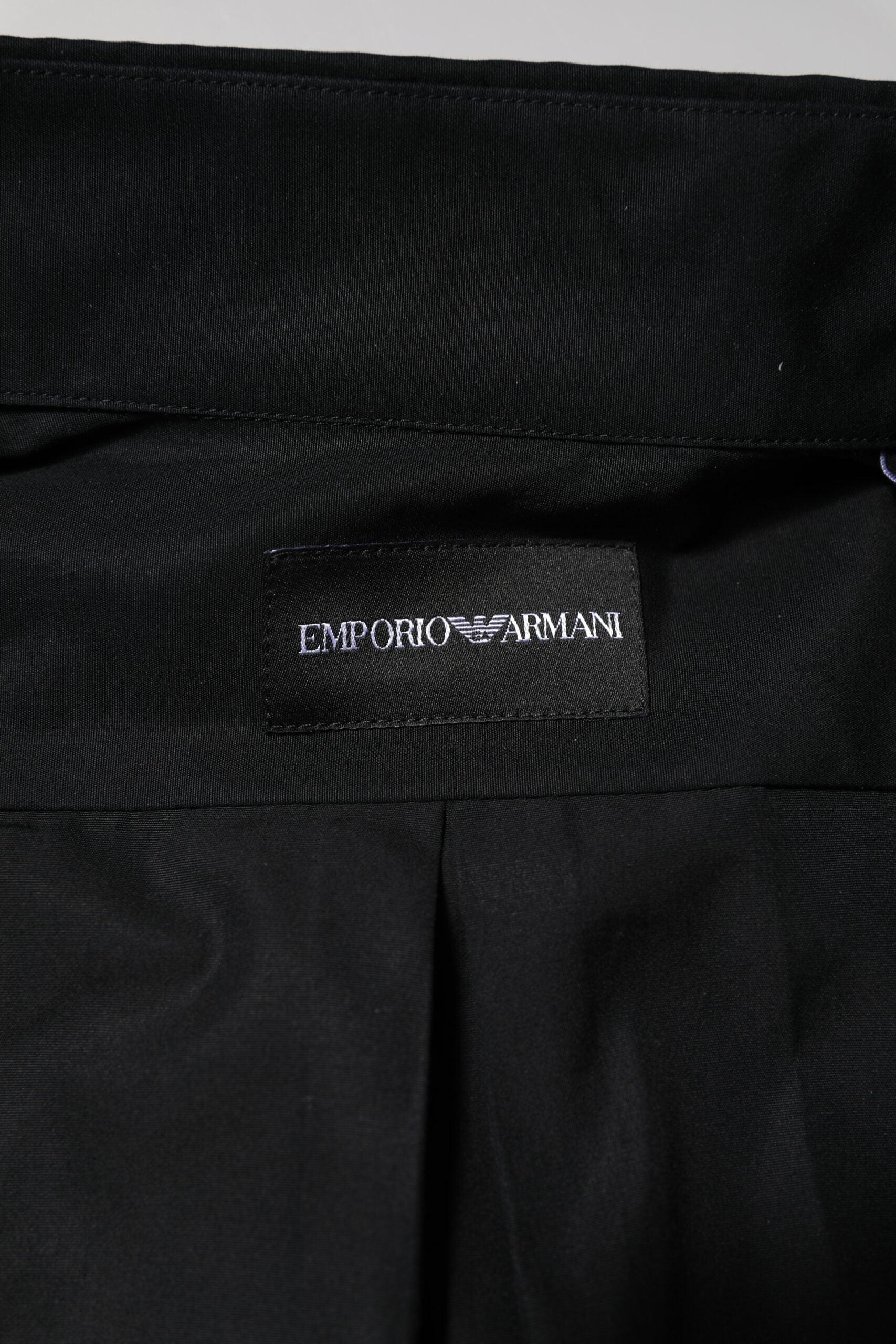A black cotton long sleeve men's formal dress shirt with a label that reads "Emporio Armani"