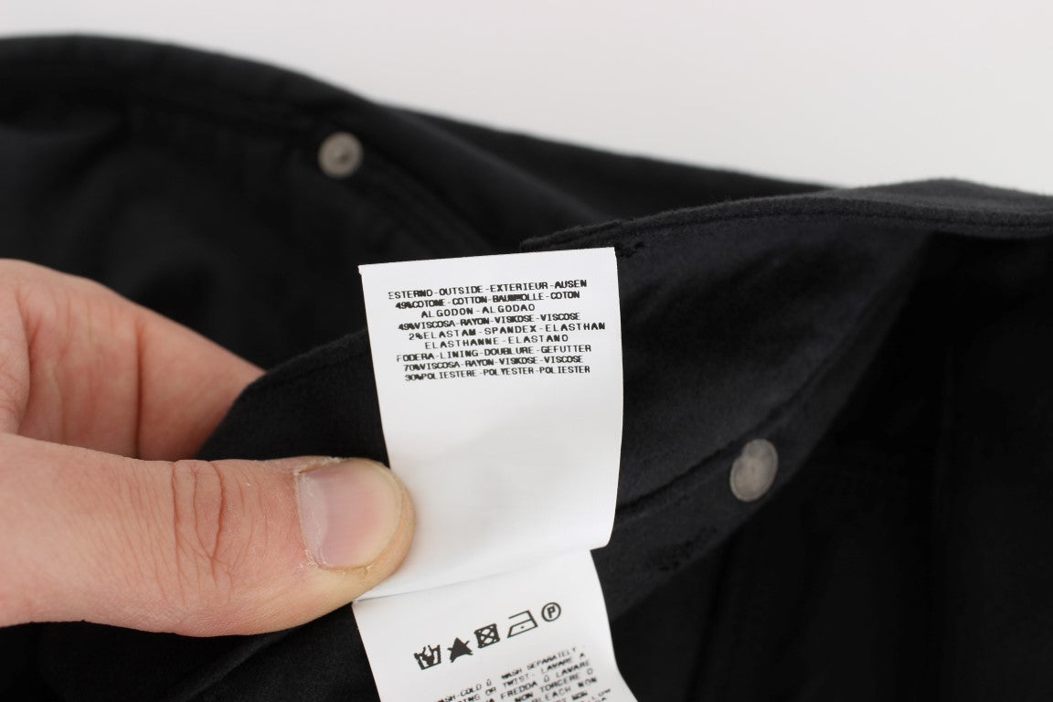 Hand holding a black shirt with white tag