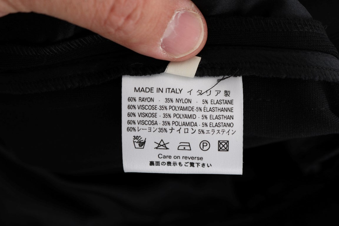 Man holding black clothing item with white label