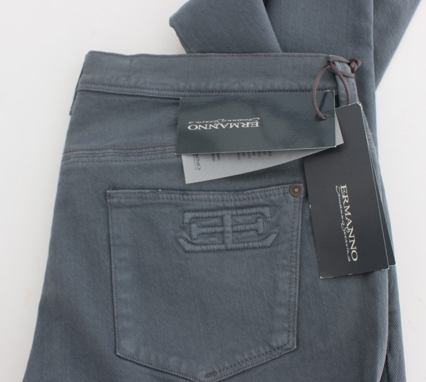 Blue jeans on a white surface with tags attached to them