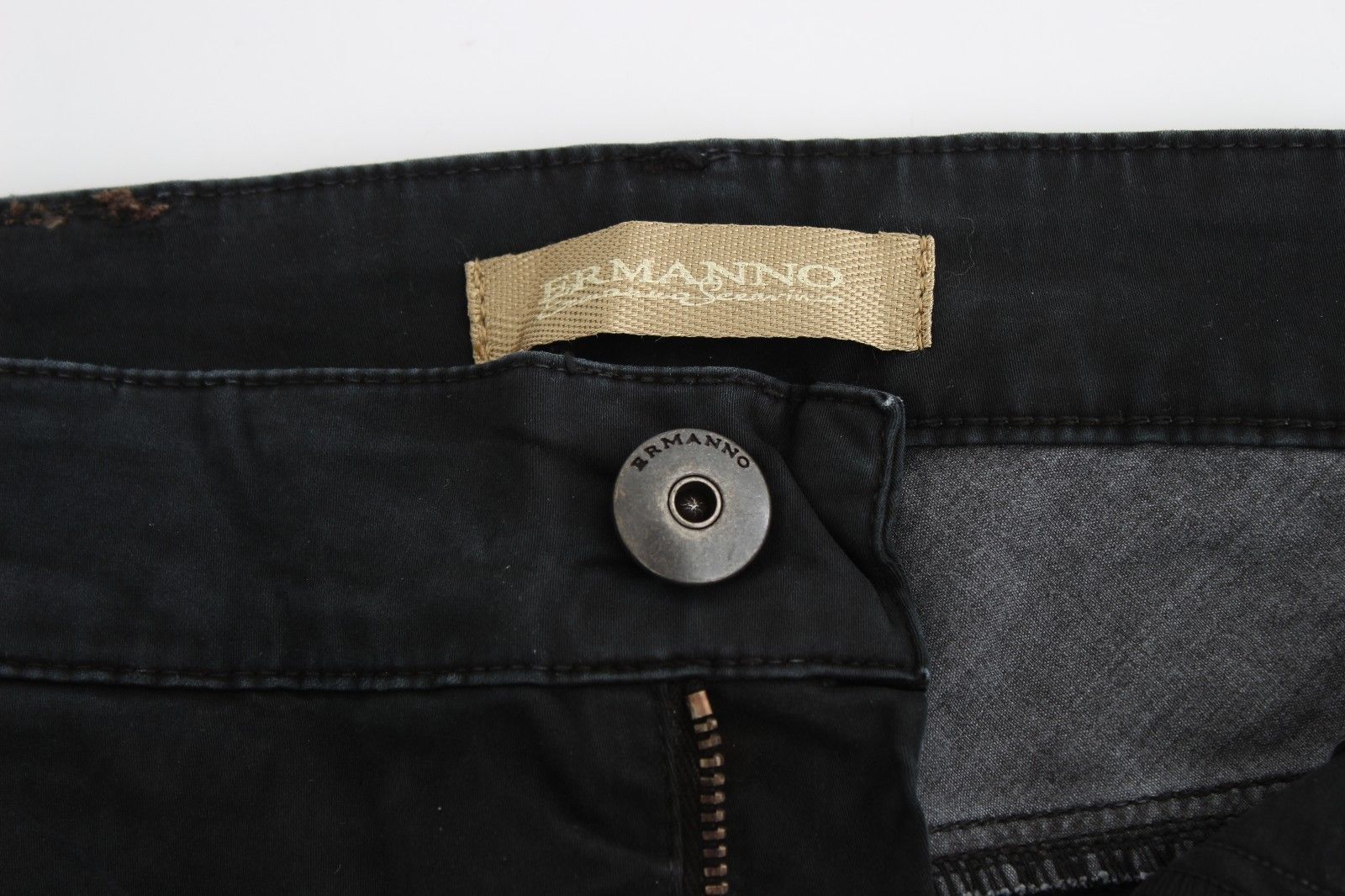 Pair of dark jeans with a gold button and zipper pull