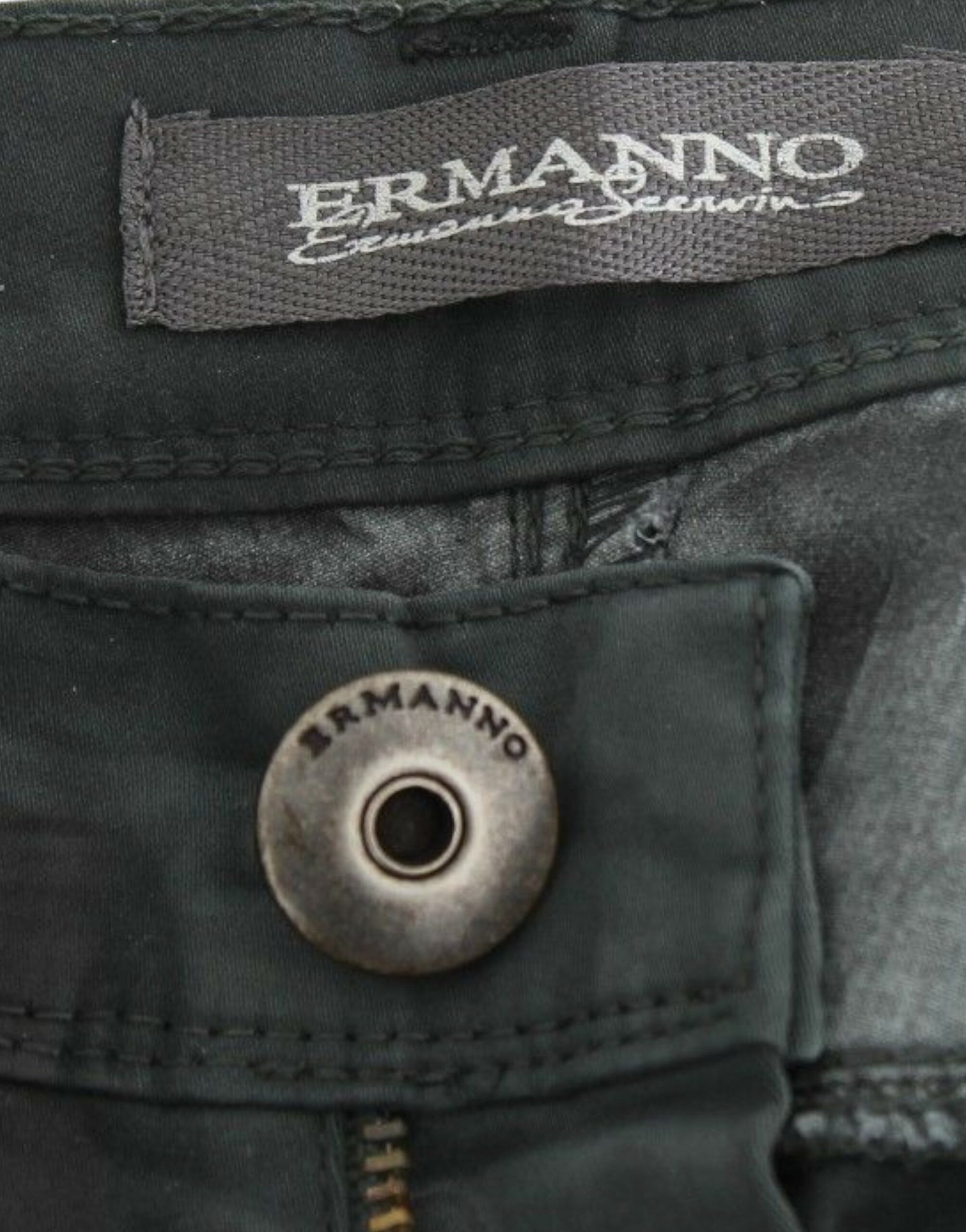 A pair of jeans with visible branding on the waistband and button. The brand name ERMANNO is printed in white letters on