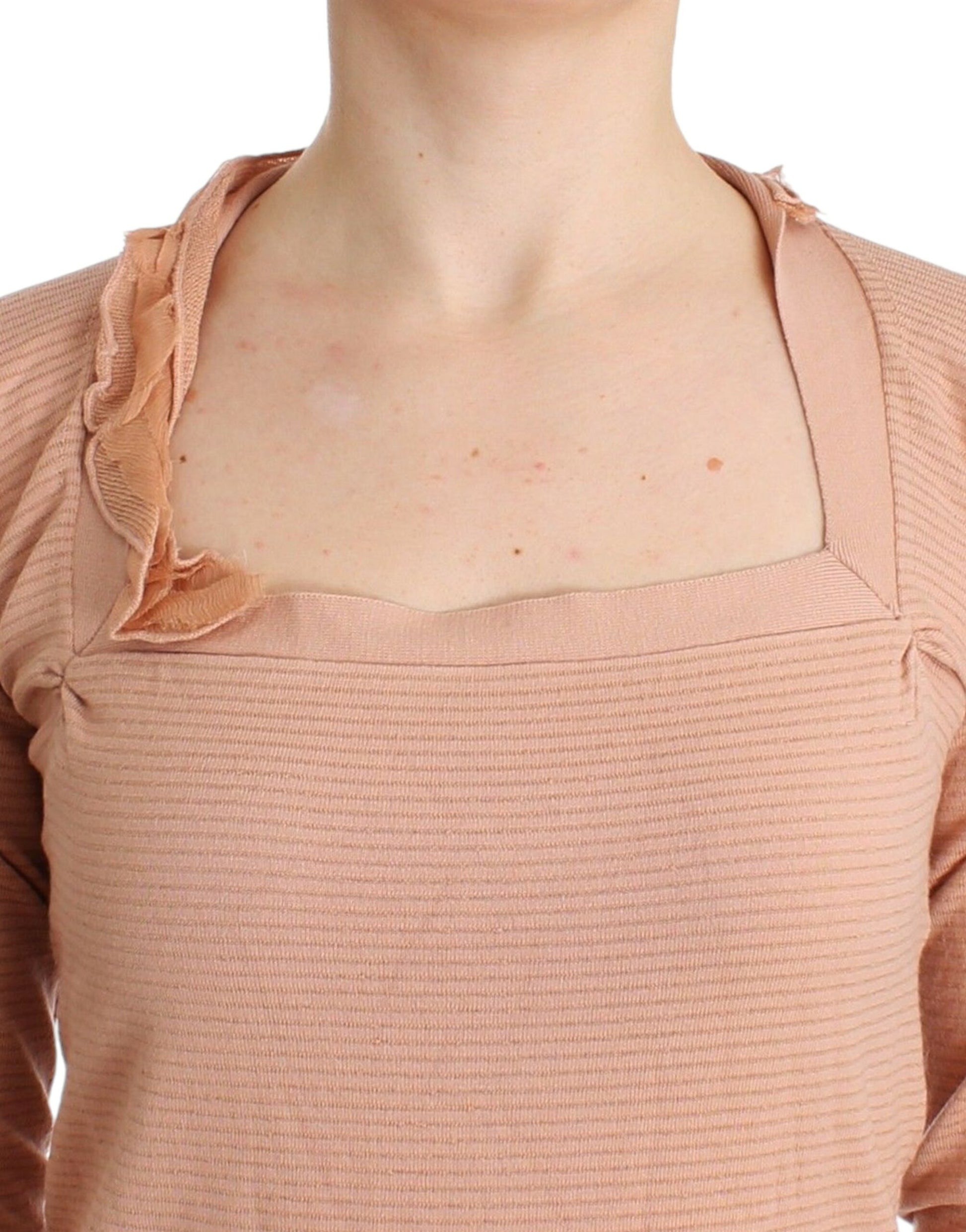 Woman wearing a pink top with ruffled sleeves