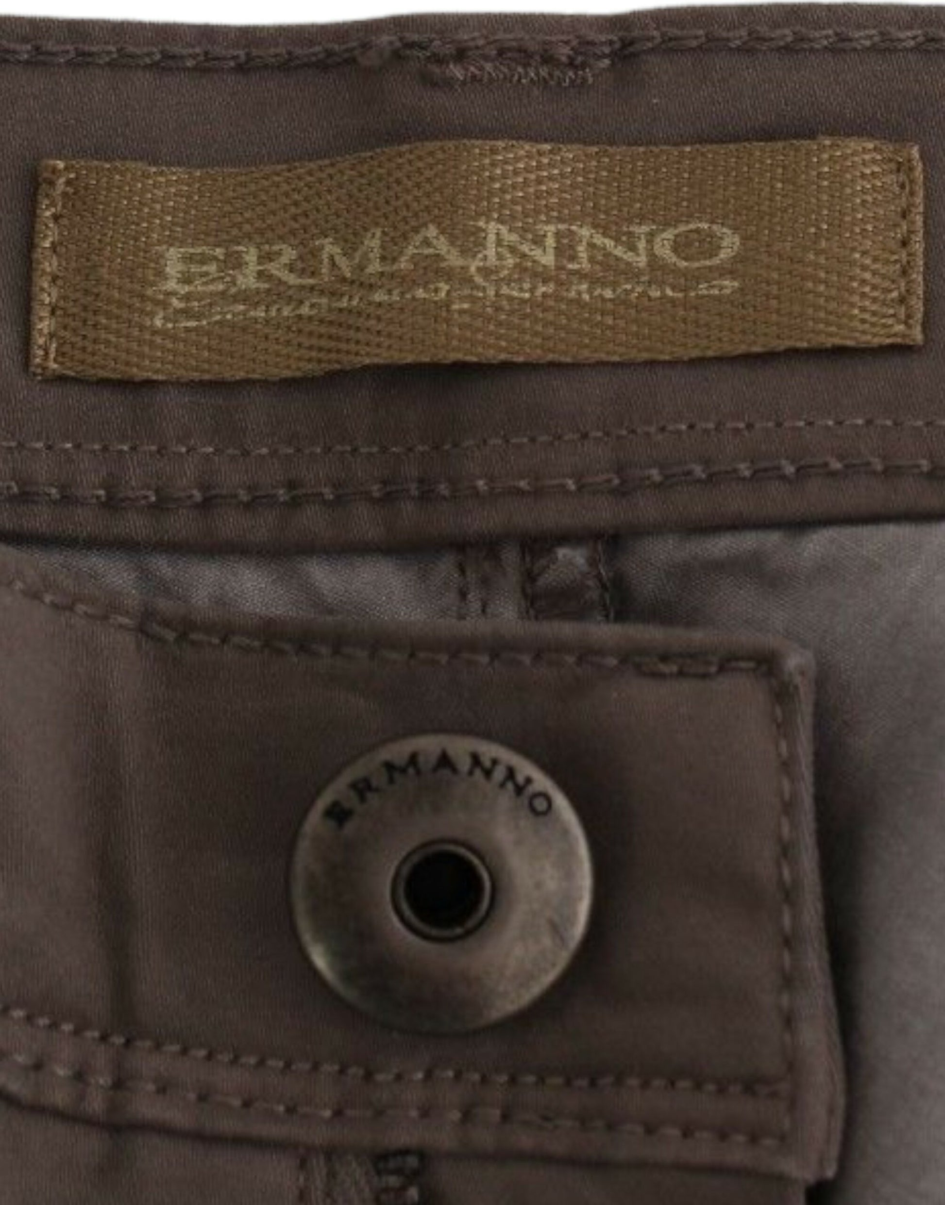 A pair of men's trousers with visible branding. On the waistband, there is a label that reads ERMANNO in capital letters