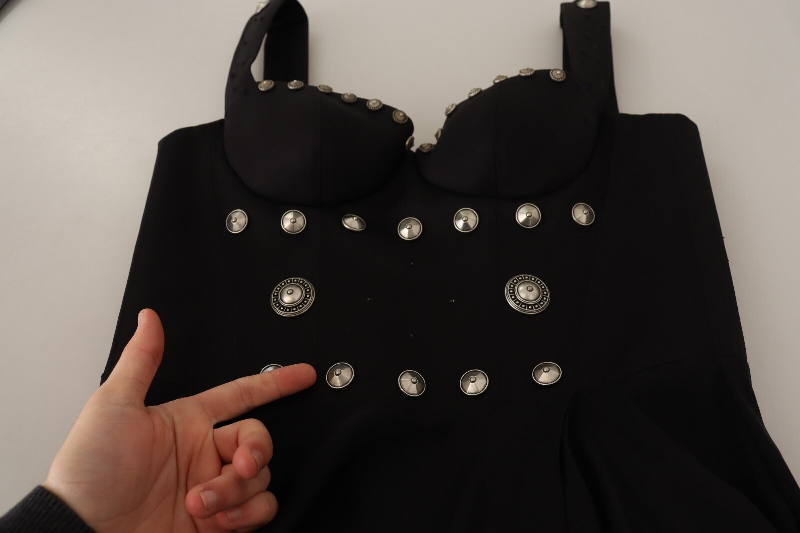A black dress with studs on the bodice and sleeves. It is an A-line maxi dress, likely made of silk, and feat