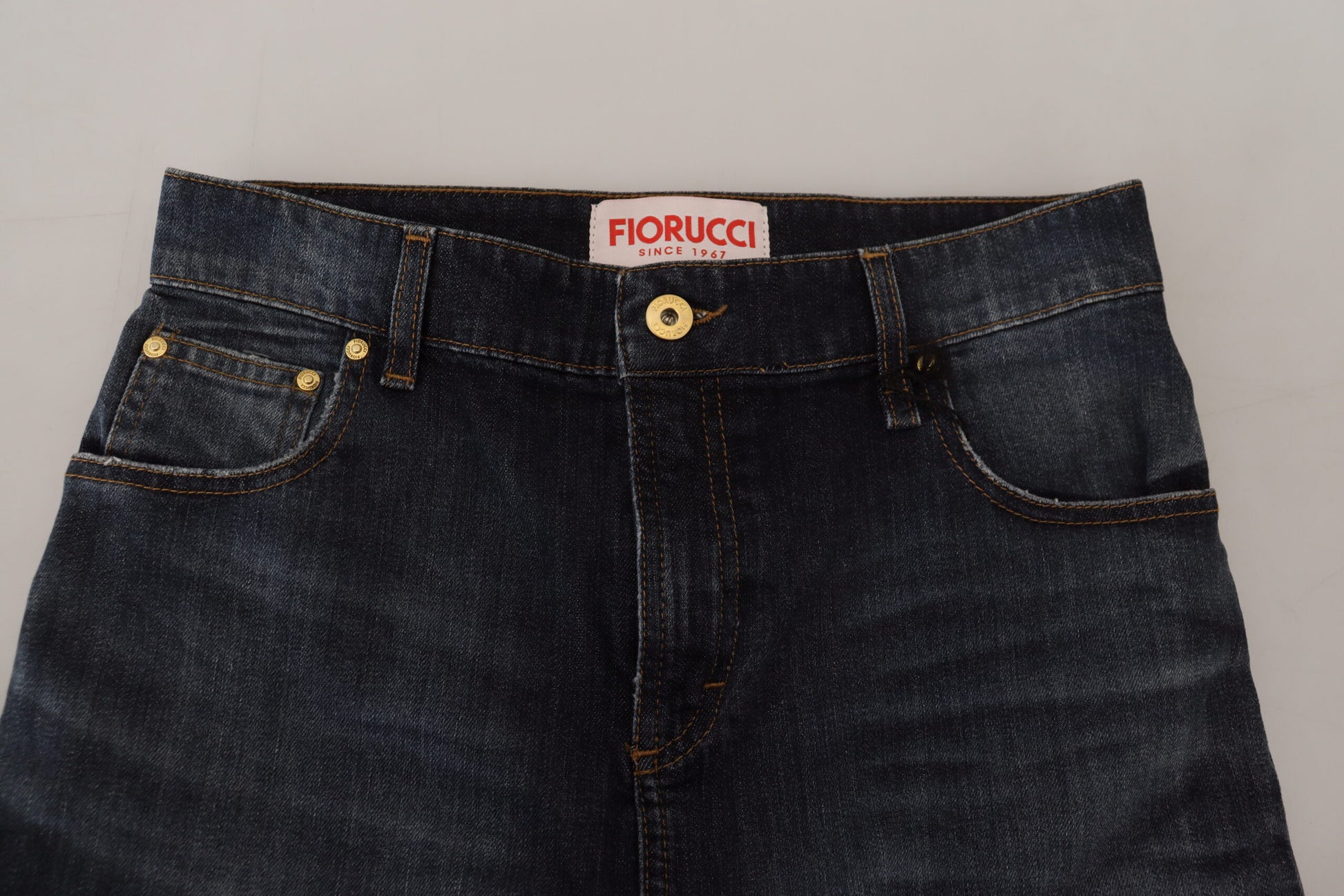 Pair of blue jeans with gold buttons on waistband