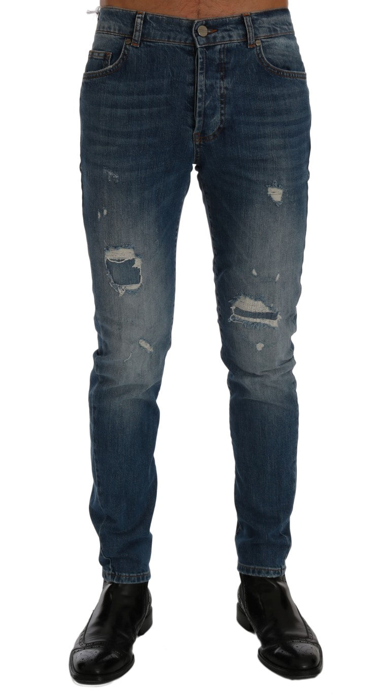 Pair of blue denim jeans with distressed areas and faded spots