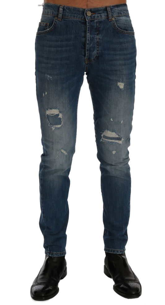 Pair of blue denim jeans with distressed areas and faded spots