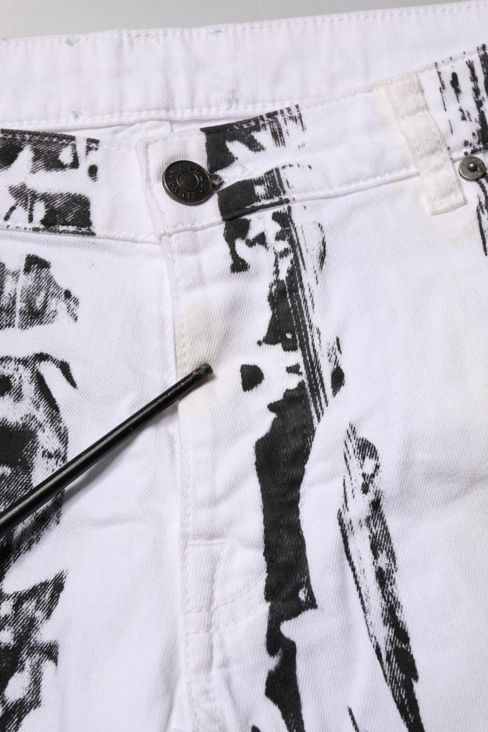 White jeans with black design on front