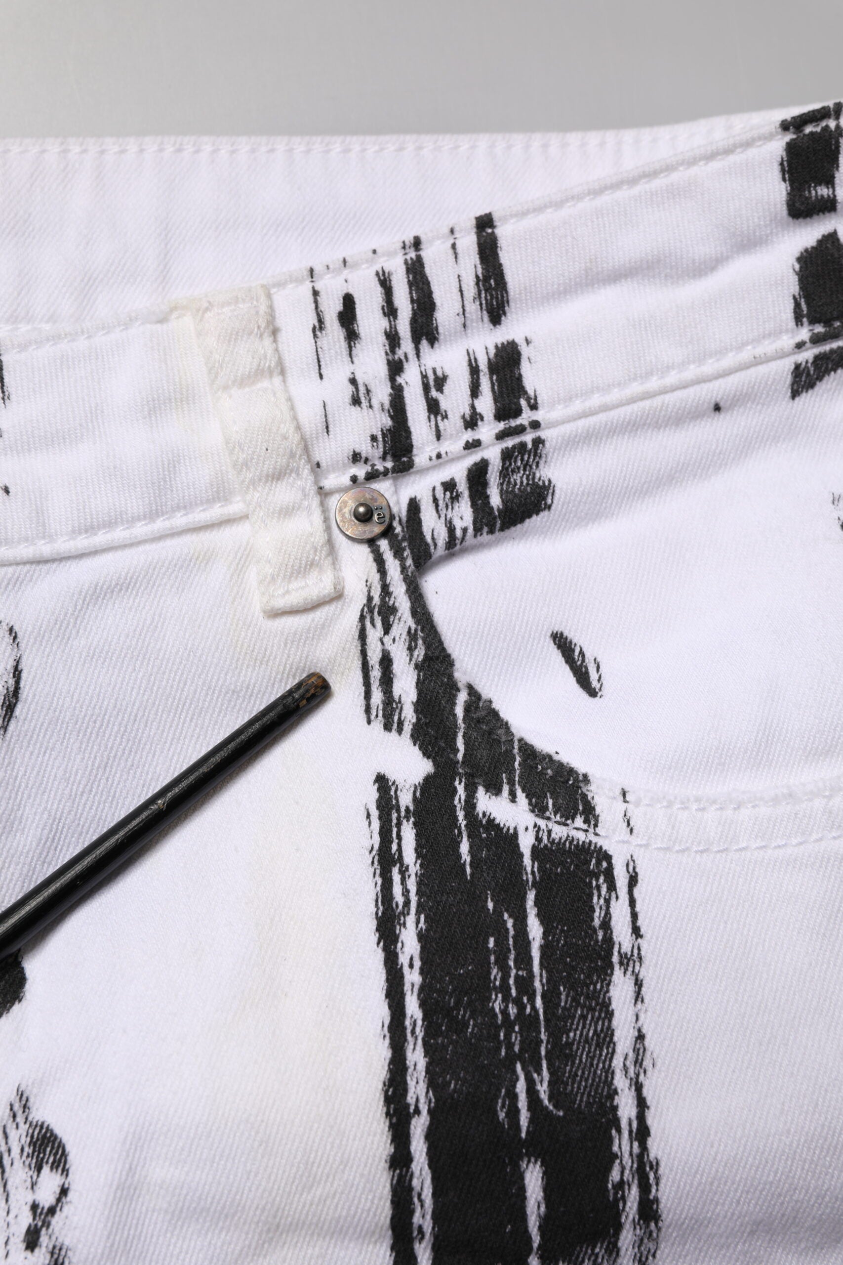 White jeans with black paint splatters on them