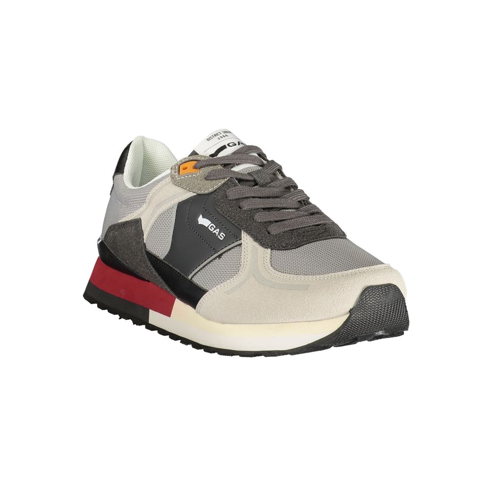 A gray sneaker with white sole and red accents