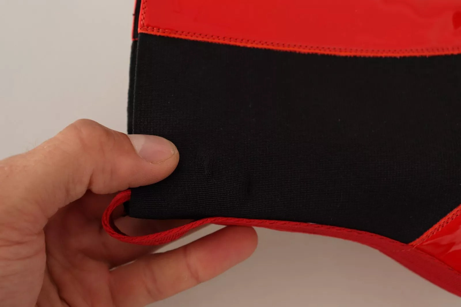 Black and red fabric item in hand
