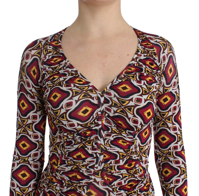 A woman wearing a long sleeve top with a patterned design on the front