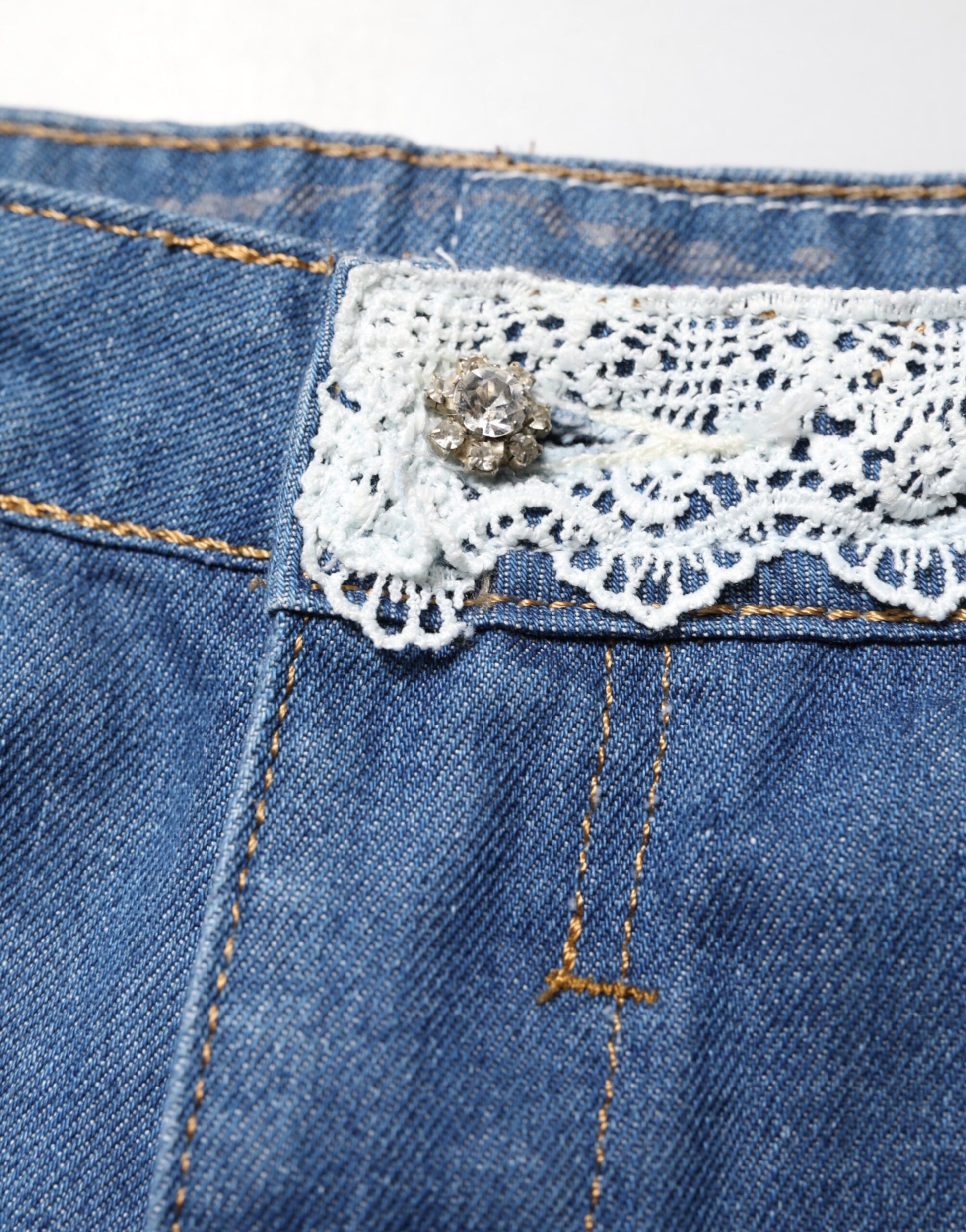 Blue denim jeans with lace trim on pocket