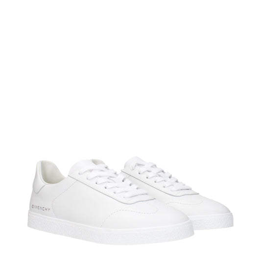 Pair of white leather low top sneakers with laces, featuring brand logo on side and sole
