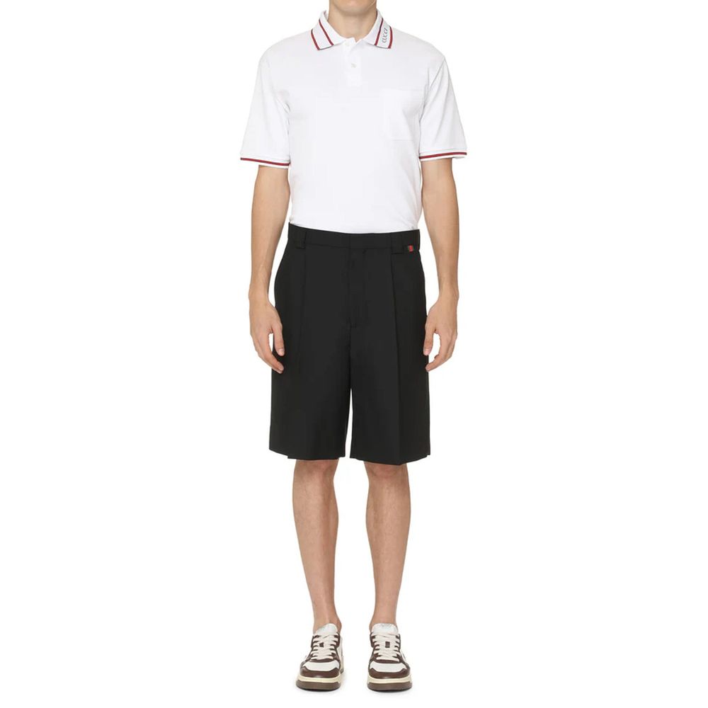 Man wearing white polo shirt and black shorts
