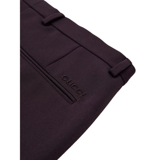 A pair of dark purple wool dress pants with a logo on the left leg