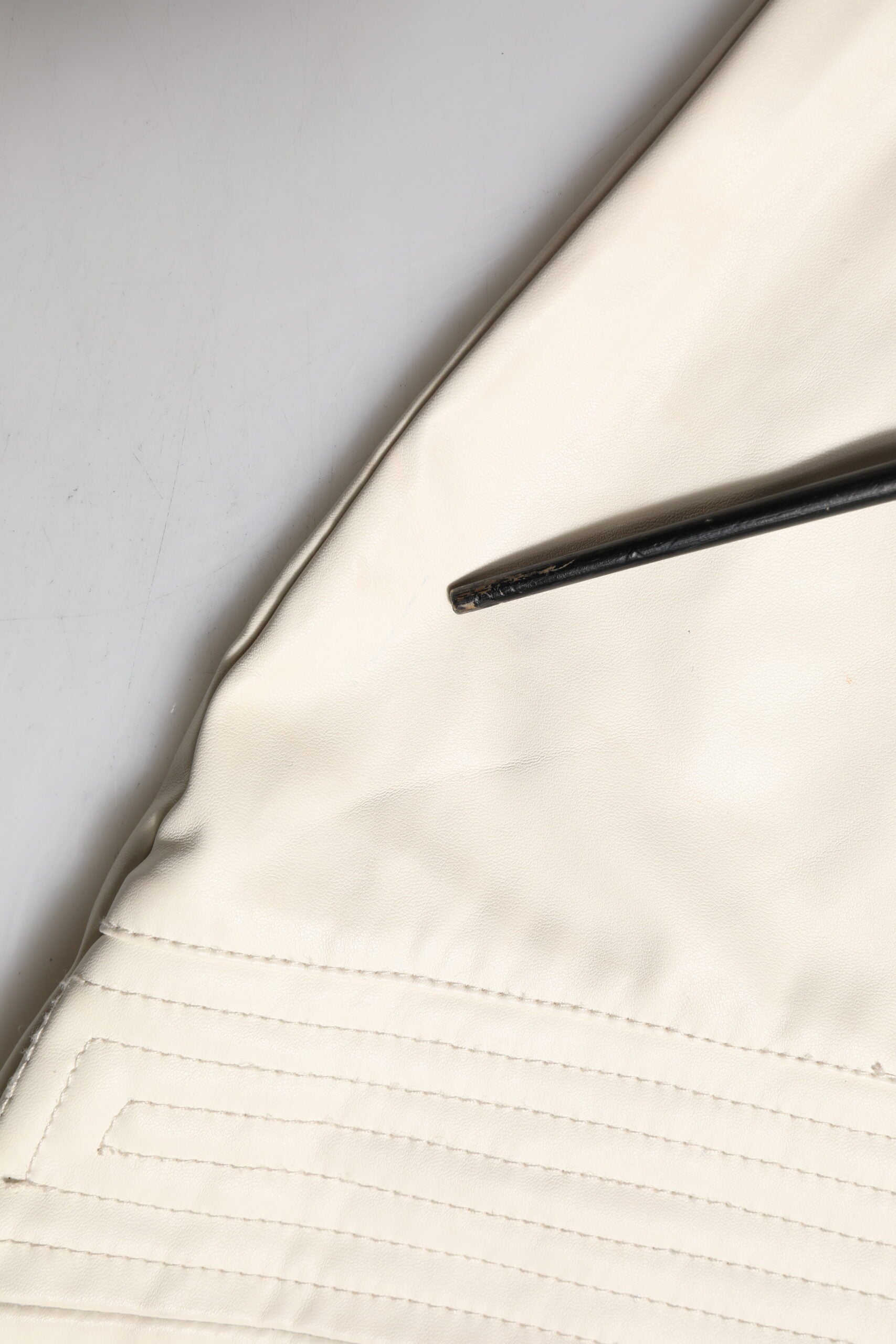 A piece of fabric with visible stitching along its edge
