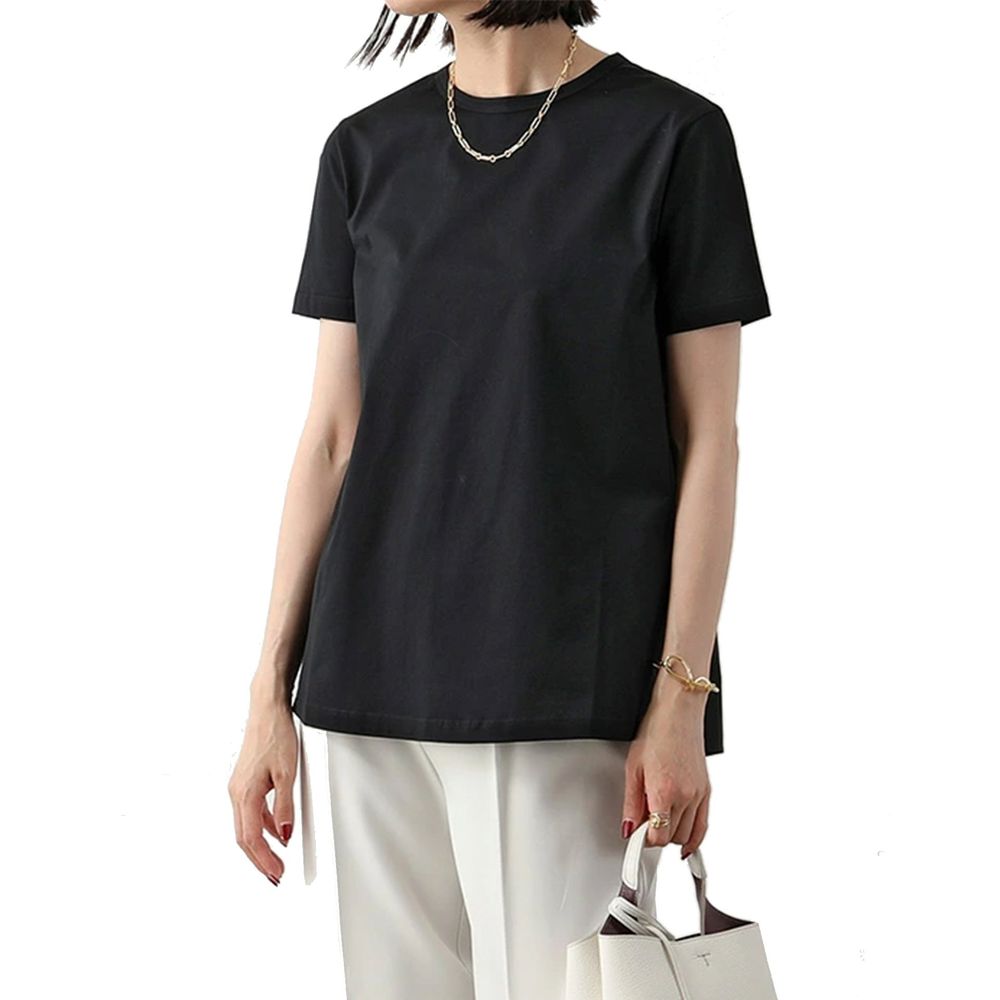 A black cotton t-shirt with short sleeves, worn by a woman standing against a white background